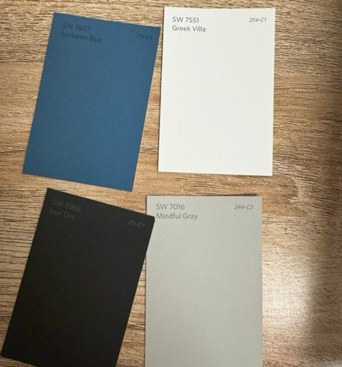 Four Sherwin-Williams paint swatches laid out on a wood surface — Santorini Blue, Greek Villa, Iron Ore, and Mindful Gray — the carefully chosen color palette for the new Mangrove Therapy Group office. These colors were selected to create a calm, cohesive environment that supports the sensitive work of trauma therapy in Delray Beach, FL. Every design decision at this Delray Beach mental health therapist practice was intentional, right down to the paint on the walls.