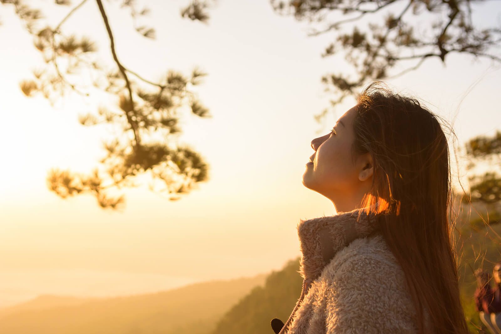 A woman closes her eyes and lifts her face to the sunset light, a picture of the calm that can follow trauma treatment in Palm Beach County, FL. Working with an emdr therapist in Palm Beach County, FL through emdr therapy in Palm Beach County, FL can help someone find this same ease.