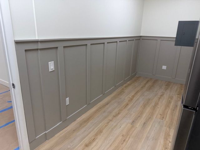 The completed breakroom featuring a handmade board and batten wall painted in Sherwin-Williams Mindful Gray, with clean white upper walls and warm wood-look flooring — a calm, polished space for the Mangrove team. This level of thoughtful design throughout the entire office reflects the values of a Delray Beach therapy practice that believes the environment itself plays a role in healing. From the therapy rooms to the staff spaces, every corner of this trauma therapy in Delray Beach, FL practice was built with purpose.