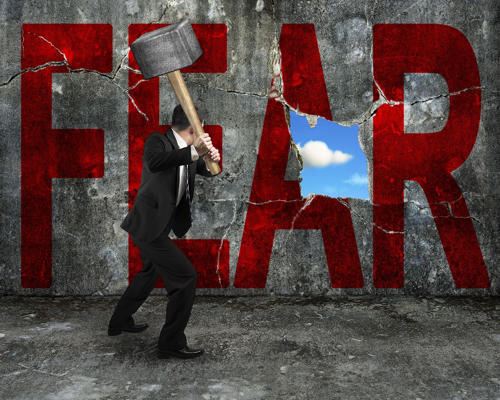 A man holds a hammer while swinging toward a cracked brick walll with the word "fear" printed across it. This could symbolize overcoming past fears in the new year. Learn how a therapist in Palm Beach County, FL can help offer support through substance abuse treatment in Delray Beach, FL and other services. 33435 | 33426 | 33487