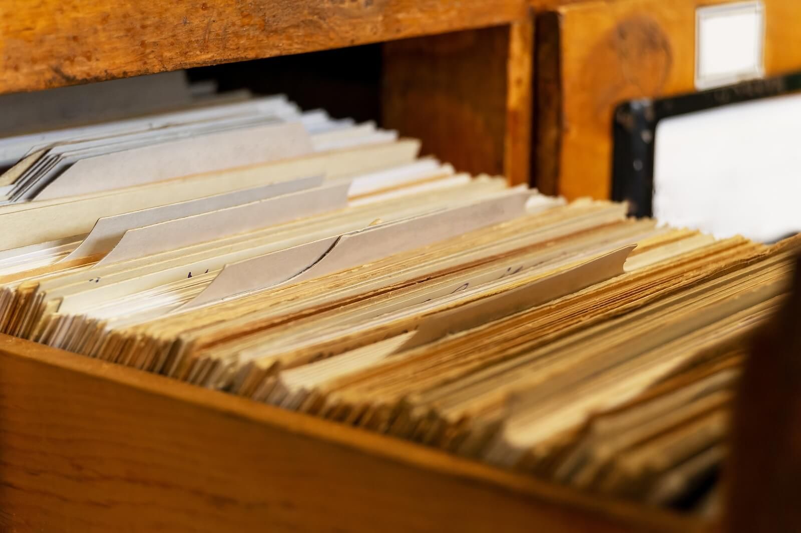 An open wooden filing cabinet packed with layered folders illustrates the blog's central metaphor — the way the brain stores traumatic memories differently from ordinary ones, keeping them easily activated by present-day triggers. A CPTSD therapist in Palm Beach County, FL uses approaches like EMDR to help the brain finally file those experiences away properly. Trauma treatment in Palm Beach County, FL is designed to help your nervous system recognize that the danger belongs in the past.