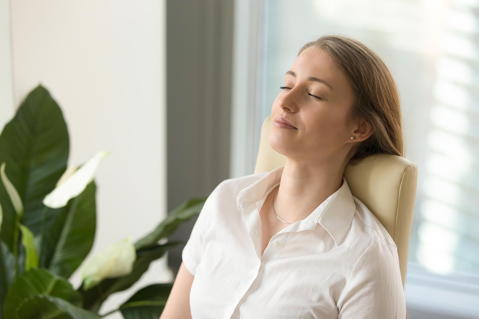 A woman sits relaxed in a chair with her eyes closed, experiencing a sense of calm and inner stillness. This peaceful state reflects the deep internal work that takes place during EMDR therapy in Delray Beach, FL. A therapist in Delray Beach, FL may guide clients into this kind of focused, restorative awareness as part of the healing process.