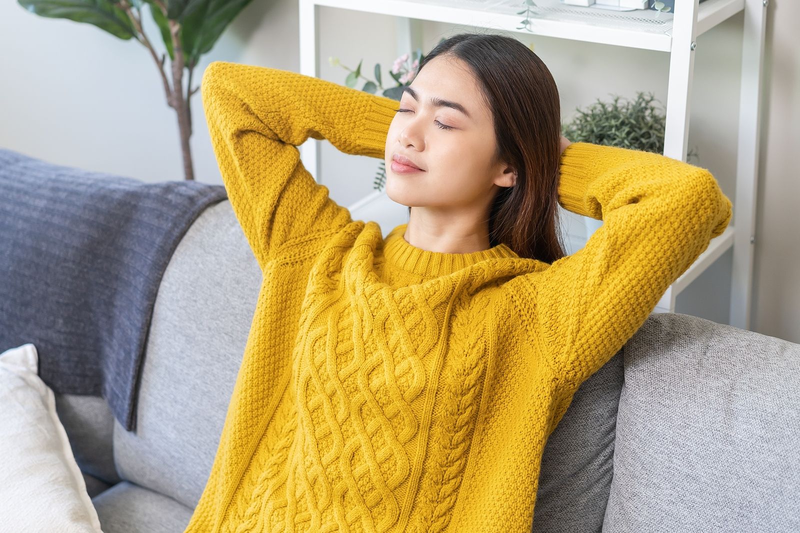 A young woman reclines on a couch with her eyes closed and arms resting behind her head, embodying the calm, absorbed state that clinical hypnosis and EMDR therapy in Palm Beach County, FL are designed to help clients access. This kind of deep internal quiet — far from unconsciousness — is exactly what an EMDR therapist in Palm Beach County, FL guides clients toward as part of the healing process.