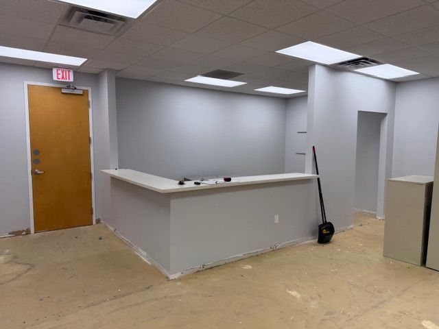A plain, unfinished office space with gray walls, bare floors, and standard white doors — the blank canvas that would eventually become the new home of Mangrove Therapy Group. This is what the space looked like before the Delray Beach therapy practice transformed it into the warm, soundproofed, and carefully designed environment it is today. Every detail of the build-out was intentional, created with the comfort and confidentiality of therapy clients in mind.
