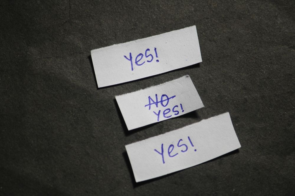 Paper notes showing “Yes” and “No” crossed out, symbolizing people-pleasing and how over responsibility is a trauma response addressed through trauma treatment in Palm Beach County, FL with a trauma therapist in Delray Beach, FL providing trauma therapy in Delray Beach, FL.