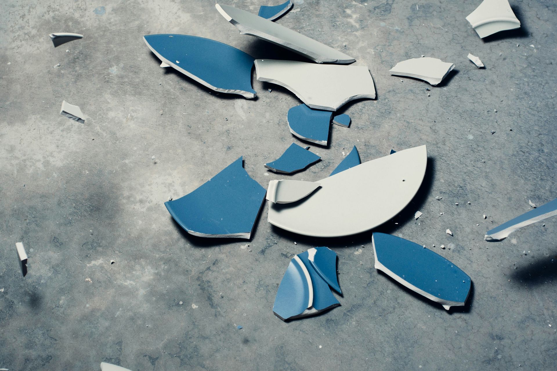 Broken ceramic pieces scattered on the ground, symbolizing emotional fragmentation often addressed in trauma treatment in Palm Beach, FL by a trauma therapist in Delray Beach, FL, especially when related to various types of addiction in Palm Beach, FL.