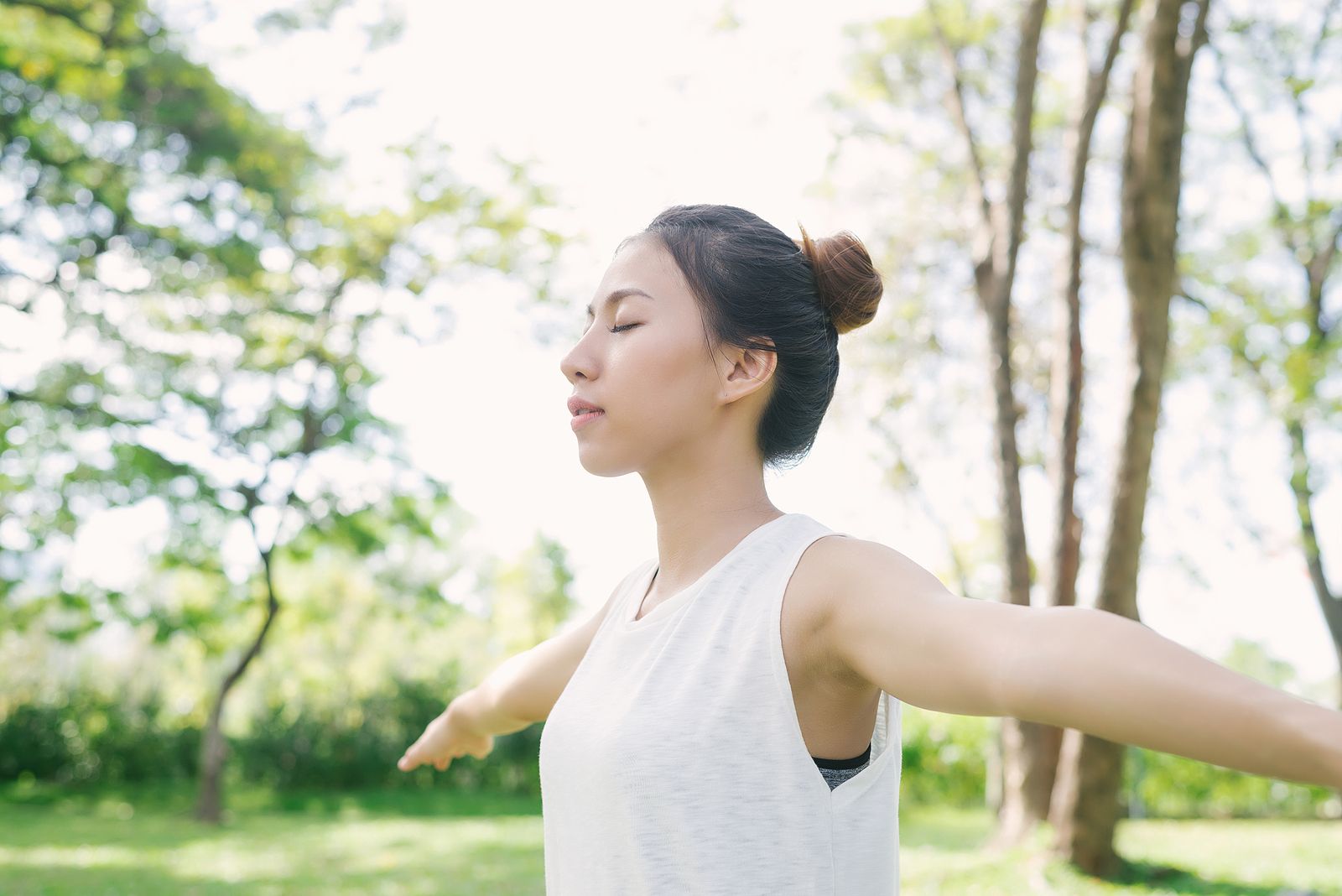 A woman stands outdoors with arms outstretched and eyes closed, breathing freely, a picture of the confidence that can follow healing from body image issues in Palm Beach County, FL through EMDR therapy in Palm Beach County, FL and support from a body image counselor in Delray Beach, FL.