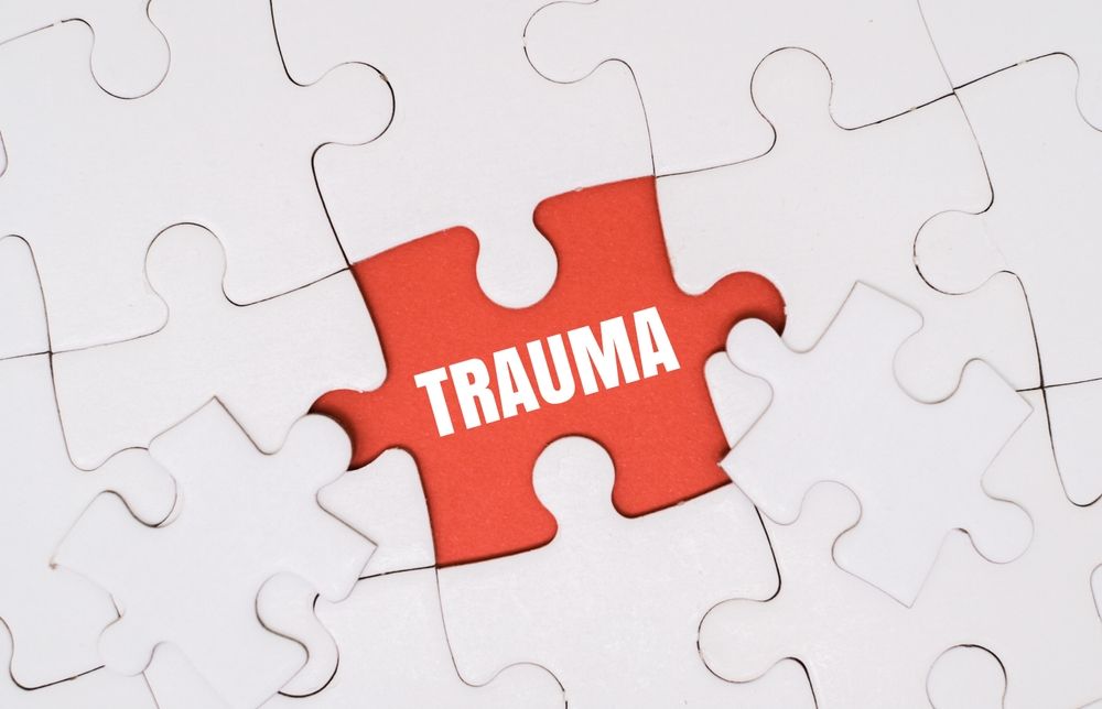 A puzzle with a missing piece revealing the word "TRAUMA" in bold red letters — a powerful visual metaphor for the hidden, underlying wounds that drive so many of the behaviors seen in The Pitt Season 2. PTSD treatment in Palm Beach County, FL targets exactly these kinds of root experiences, helping clients finally fill in the missing piece. Trauma therapy in Boca Raton, FL and the surrounding area offers an evidence-based path toward processing what has long been buried beneath the surface.