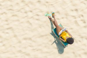A woman reads a book while lounging on the beach. Learn how St. Pete therapy can offer support with mental wellness by searching for a therapist in St. Pete, FL. Contact a psychologist in St. Pete, FL for more info on eating disorder treatment in St. Pete, FL.