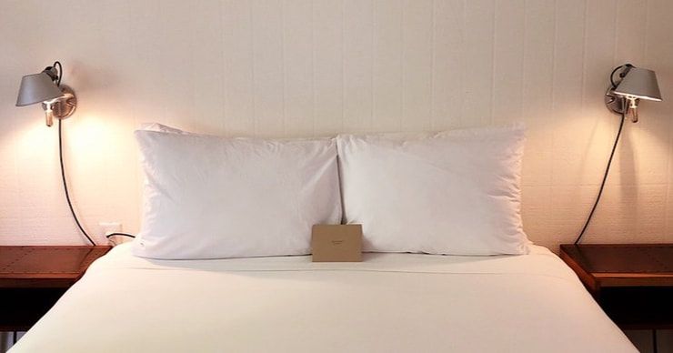 Photo of a bed with two lights on either side to represent the relationship between sleep and mental health. Our psychologists help individuals in the Tampa area get better sleep.