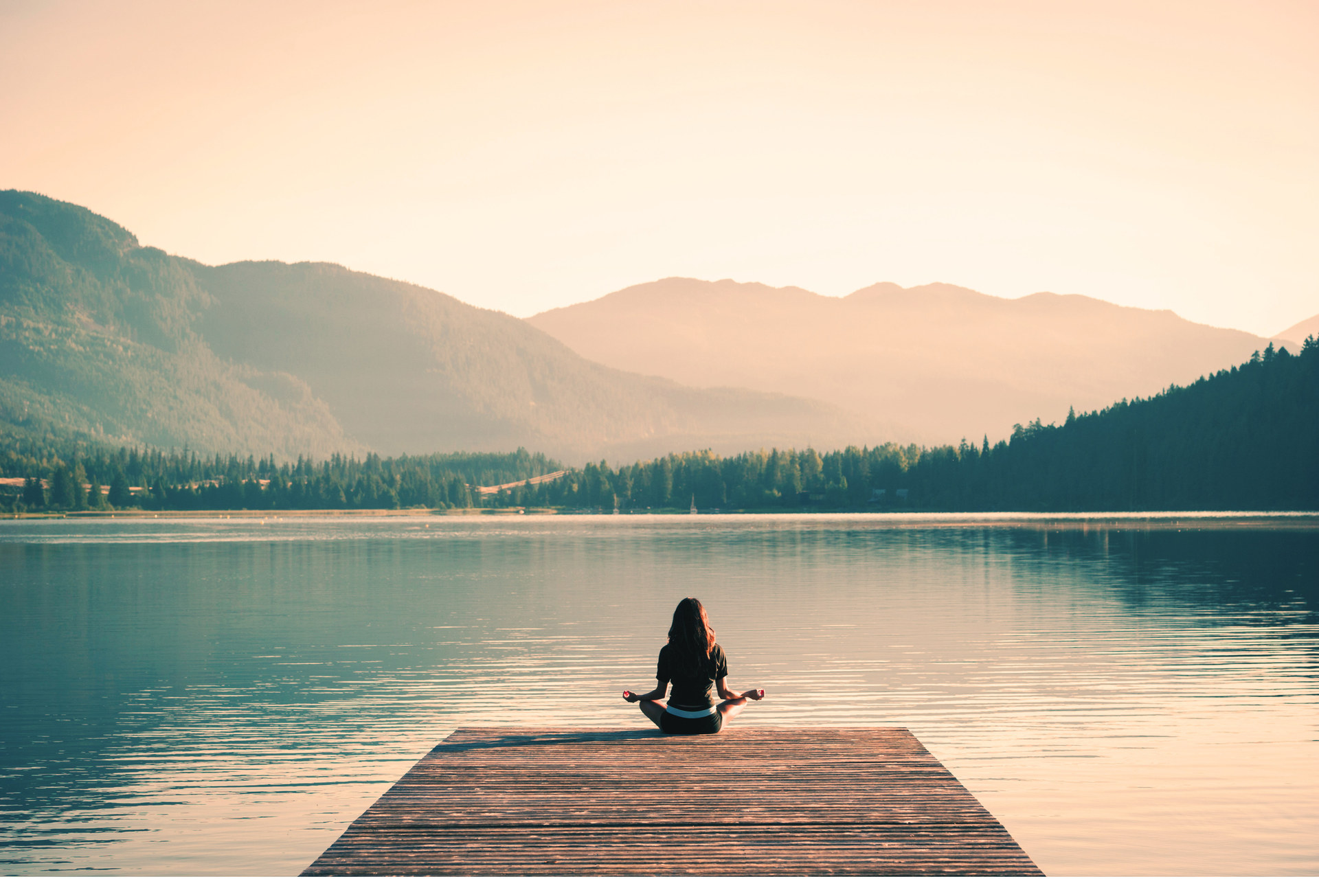 woman sitting on dock meditating
