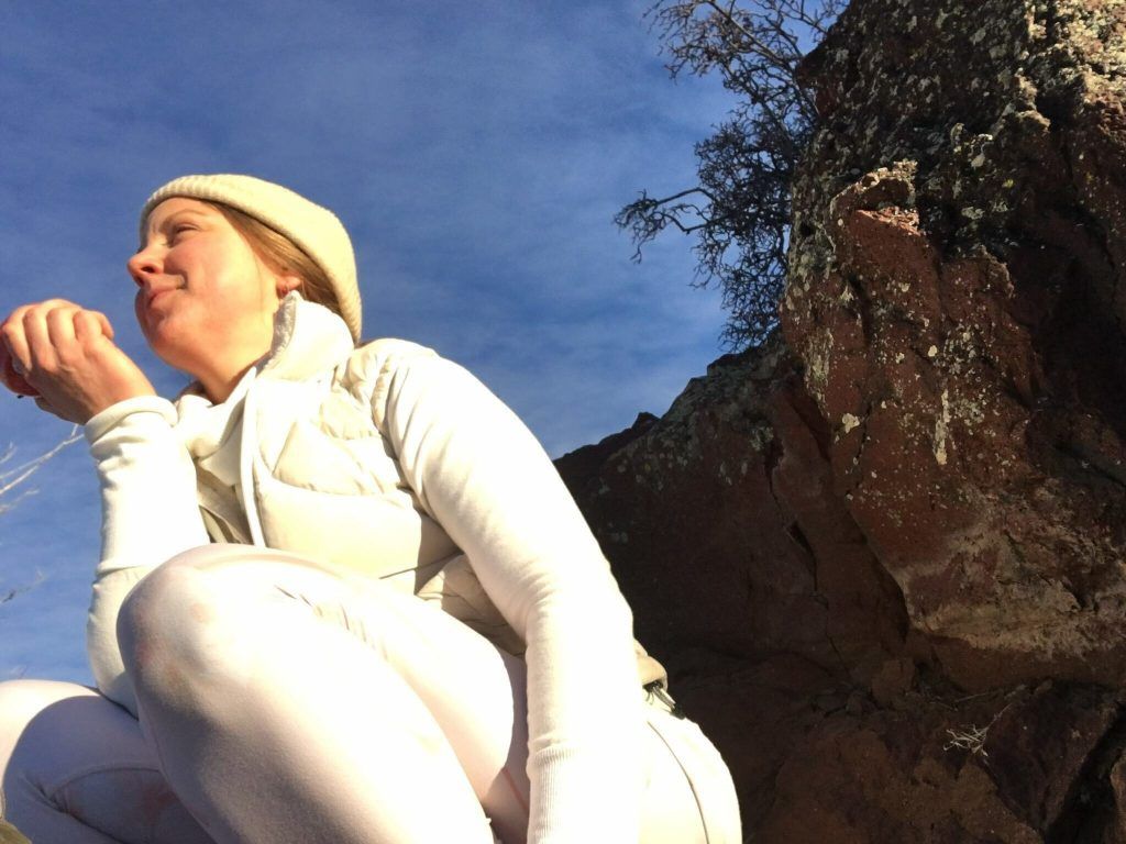 Woman in white squatting outdoors | "A Lifetime of Hiding My Thighs" by Emily Wishall | Wishall Wellness Coaching for Women | Boulder, CO 80305