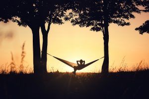 A person relaxes in a hammok while enjoying the setting sun. This could represent the peace of mind treatment for depression in Atlanta, GA can offer. Learn more about our services by contacting a depression therapist in Atlanta, GA today.