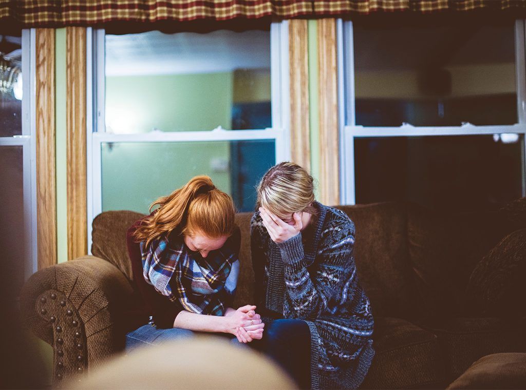 A couple cover their faces as they hold hands and sit together. Learn how a grief counselor in Atlanta, GA can offer support for your relationship. Learn more about online grief counseling in Atlanta, GA and other services by contacting a couples therapist today.