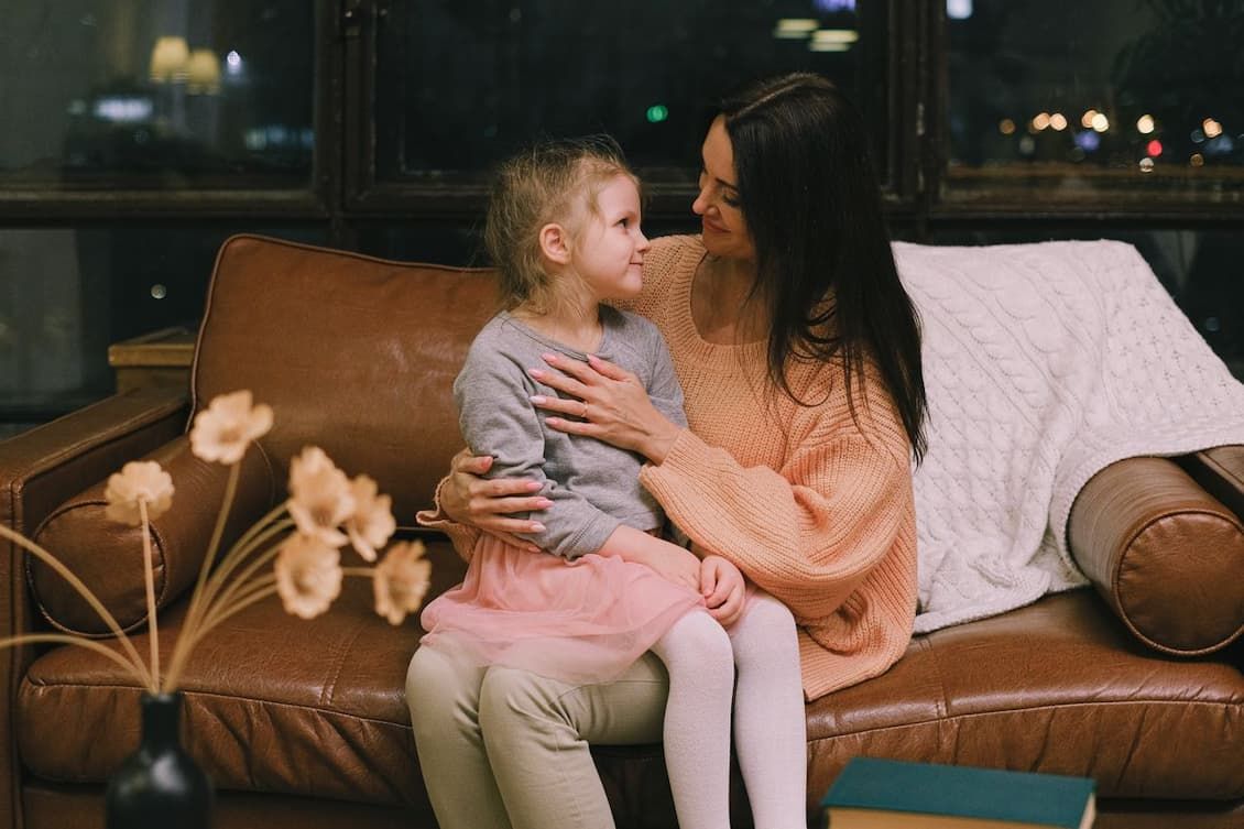 girl-sitting-on-the-lap-of-a-woman-looking-at-each-other